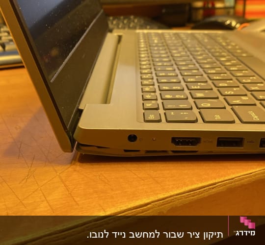 מחשב נייד עם חיבורים בצד, מסך נוסף ברקע